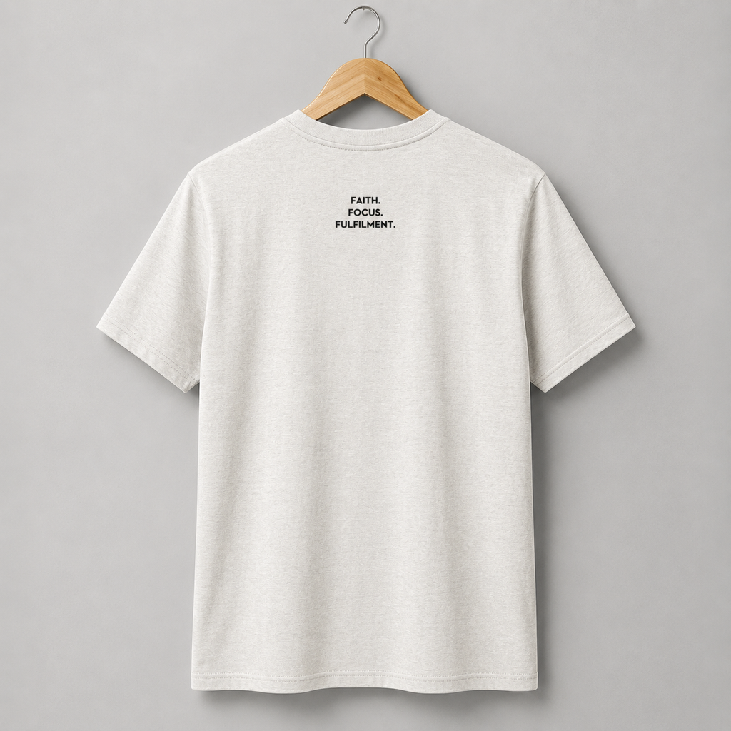A vintage white short-sleeve crewneck t-shirt hanging on a wooden hanger. The back of the shirt features a small slogan Faith. Focus. Fulfilment. in black text between the shoulder blades.