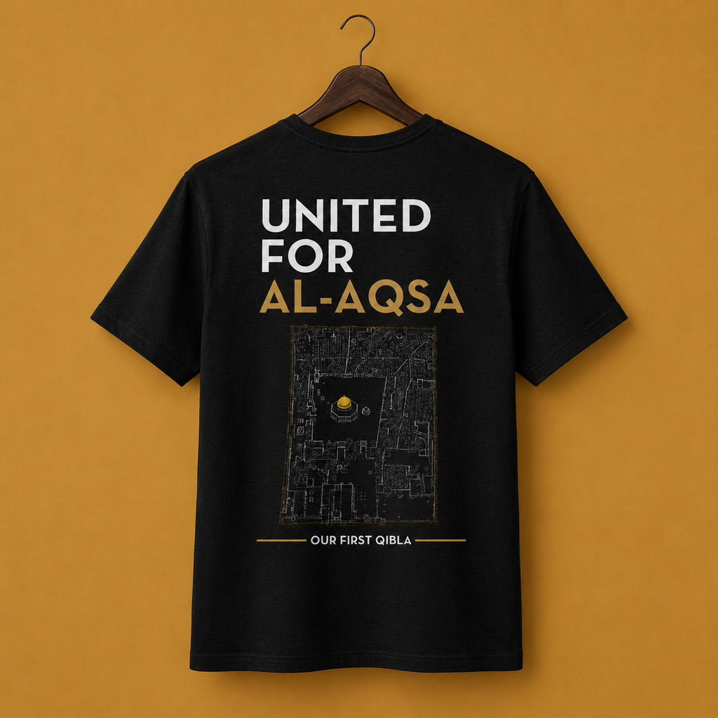 A black short-sleeve t-shirt hanging on a wooden hanger. The back of the shirt features a print with the text 'UNITED FOR AL-AQSA' in white and gold, with map on the Al-Aqsa compound in the center, and 'OUR FIRST QIBLA' in white text at the bottom.