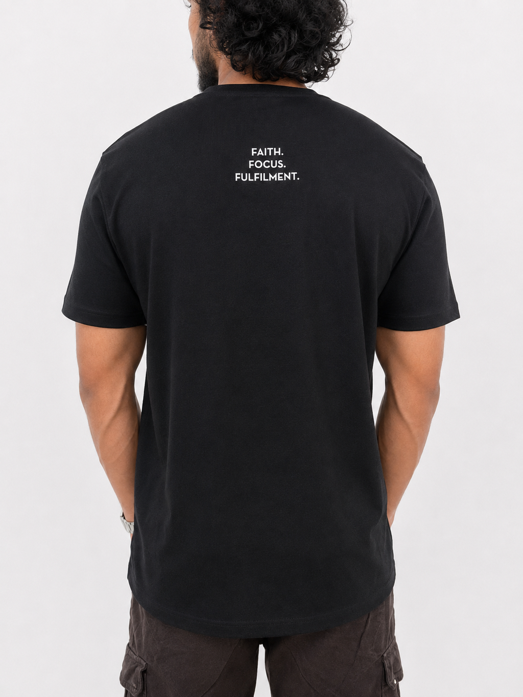 A man viewed from behind wearing a black short-sleeve t-shirt with the words 'FAITH. FOCUS. FULFILMENT.' between shoulder blades.