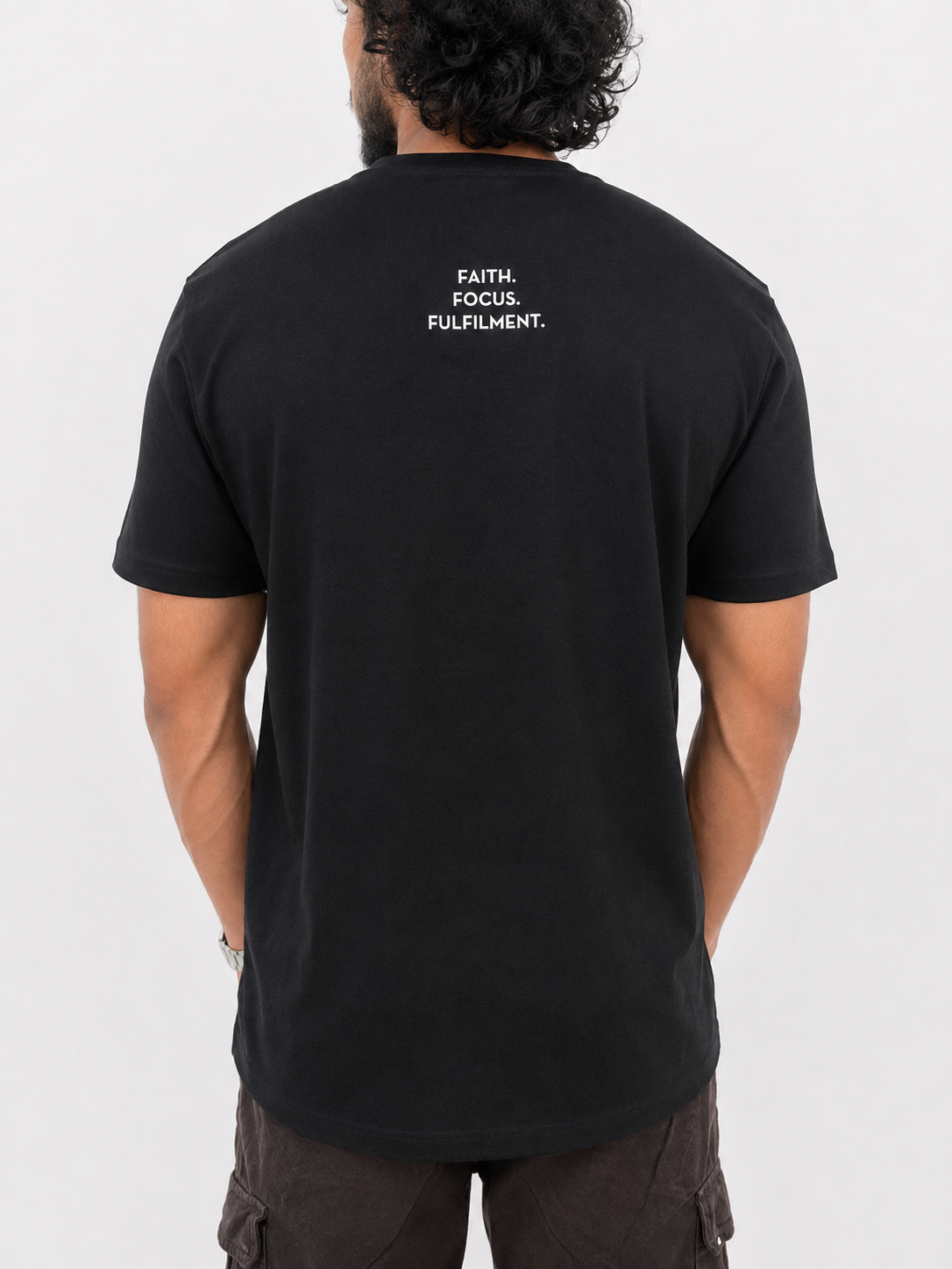 A man viewed from behind wearing a black short-sleeve t-shirt with the words 'FAITH. FOCUS. FULFILMENT.' between shoulder blades.