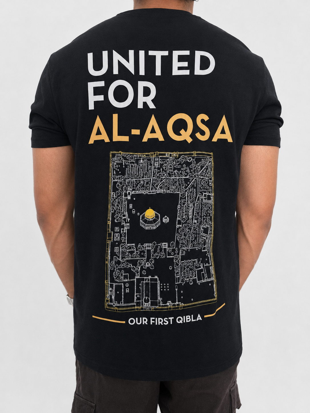 A man wearing a black t-shirt from the back, featuring a large graphic print with the text 'UNITED FOR AL-AQSA' in white and gold, and a detailed map illustration of the Al-Aqsa compound with the phrase 'OUR FIRST QIBLA' at the bottom.